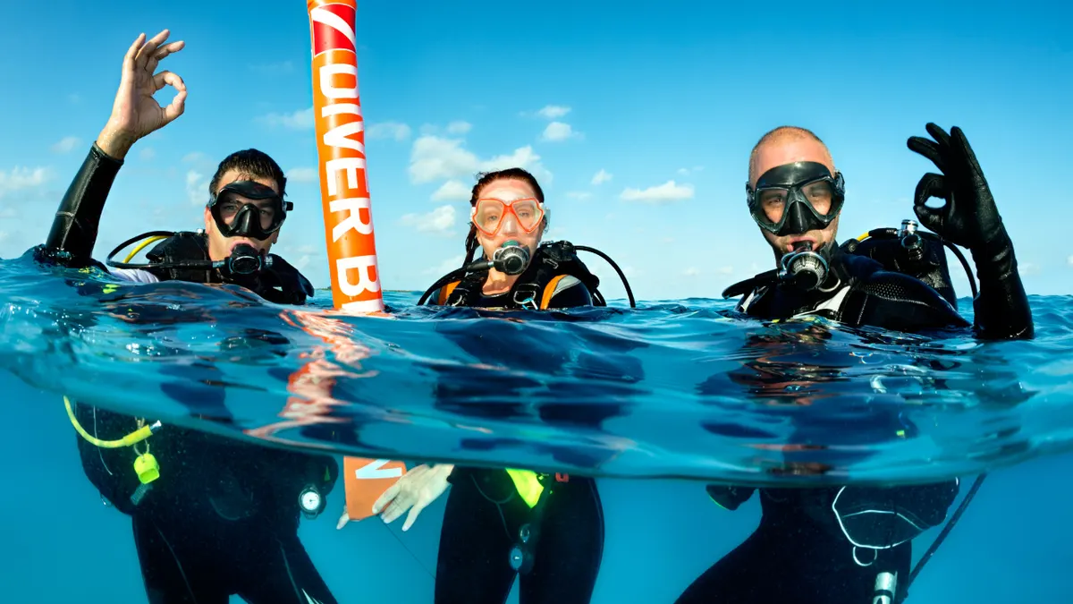 Happy divers giving OK sign underwater